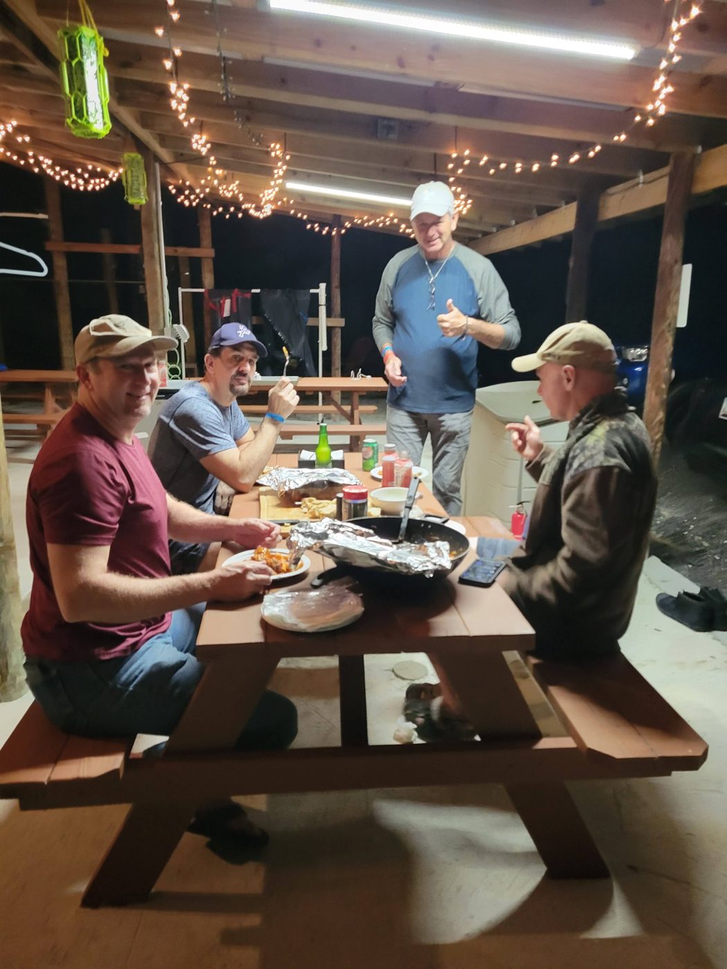 Divers eating dinner at a picnic table at night