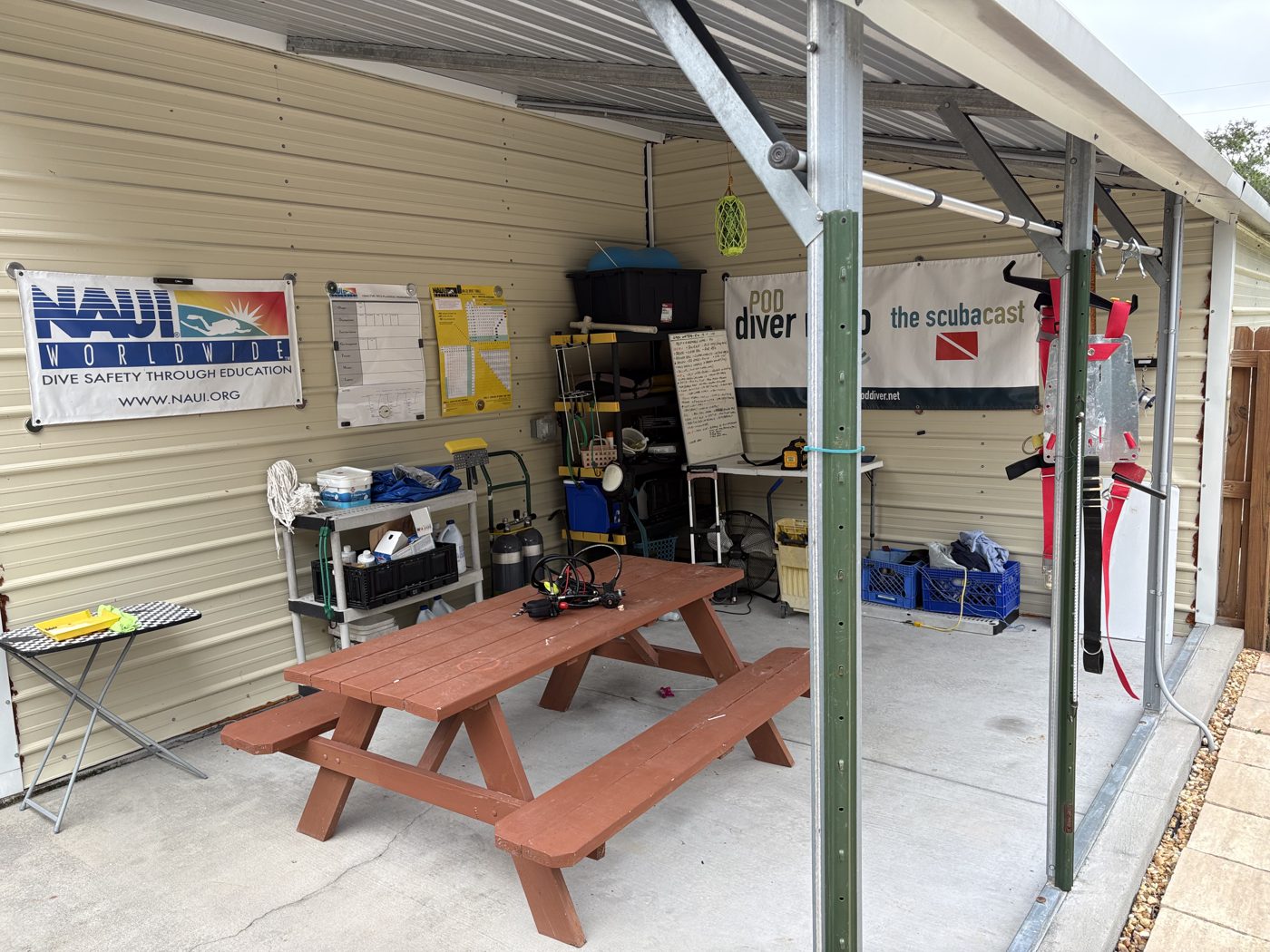Covered classroom with a picnic table, NAUI banner and gear racks